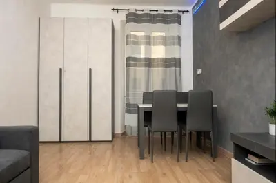 a dining room with a table and black chairs at Apartment Colli [3m metro] in Rome