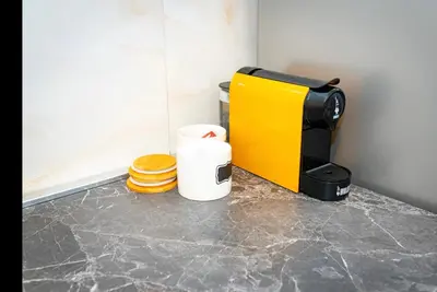 a coffee maker on a counter next to a stack of pancakes at Apartment Colli [3m metro] in Rome