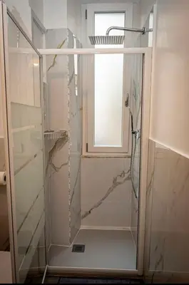 a glass shower in a bathroom with a window at Apartment Colli [3m metro] in Rome