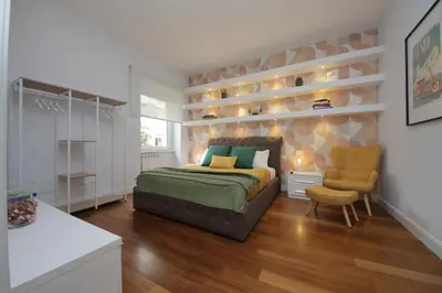 a bedroom with a bed and a chair in it at YCH-Stylish 3 bedrooms apartment near Vatican in Rome