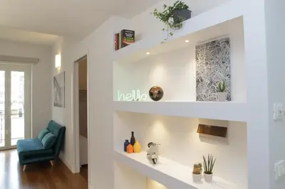a living room with white walls and a blue chair at YCH-Stylish 3 bedrooms apartment near Vatican in Rome