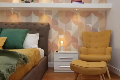 a bedroom with a bed and a yellow chair at YCH-Stylish 3 bedrooms apartment near Vatican in Rome