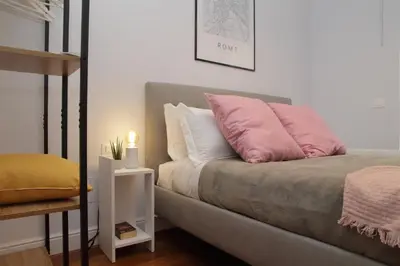 a bedroom with a bed with pink and white pillows at YCH-Stylish 3 bedrooms apartment near Vatican in Rome