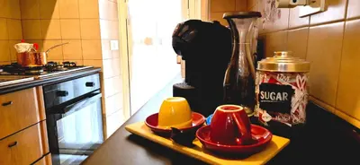 a kitchen counter with red dishes on a tray at A casa di chi, Family, Near Metro in Rome
