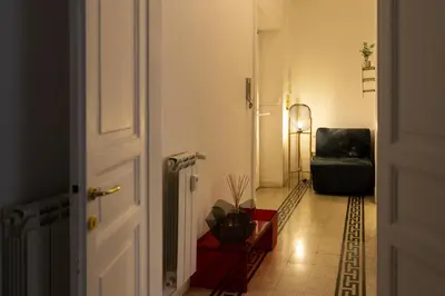 a hallway with a chair and a room with a door at Giuliana Apartment Vatican in Rome