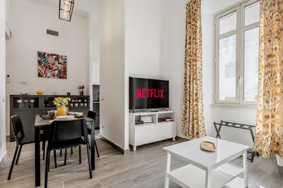 a living room with a dining table and a tv at Elena's house in Rome