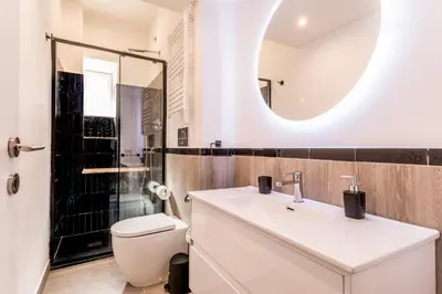 a bathroom with a sink and a toilet and a mirror at Elena's house in Rome
