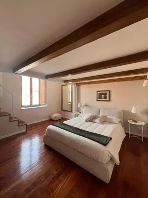 a large bedroom with a large bed and wooden floors at Penthouse 23 - Vatican Charming Apartment in Rome
