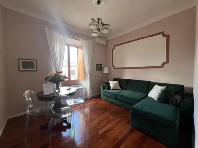 a living room with a green couch and a table at Penthouse 23 - Vatican Charming Apartment in Rome
