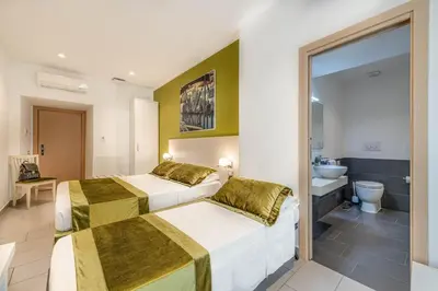 a hotel room with two beds and a bathroom at Trevi Palace Hotel in Rome