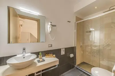 a bathroom with a sink and a shower at Trevi Palace Hotel in Rome