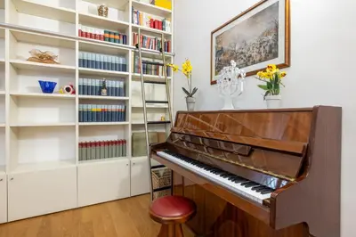 a piano in a room with a book shelf at Vatican home garden by Varental in Rome