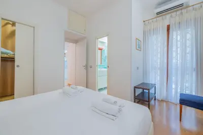 a white bedroom with a white bed and a mirror at Vatican home garden by Varental in Rome