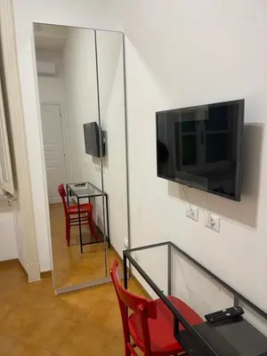 a living room with a table and a television on a wall at Greg Roma in Rome