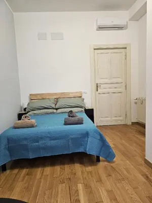 a bedroom with a bed with a blue comforter at Greg Roma in Rome