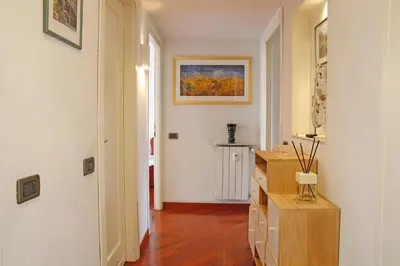 a hallway with white walls and a wooden floor at Valerio’s House in Rome