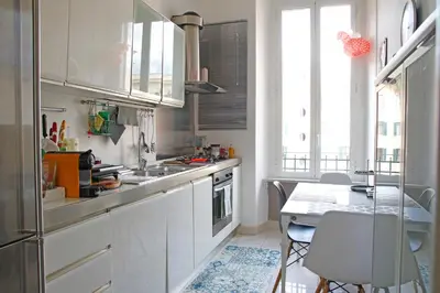 a kitchen with white cabinets and a table with chairs at Valerio’s House in Rome