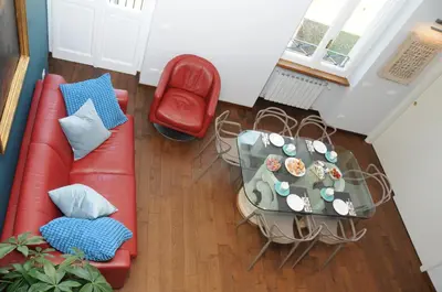 a living room with a red couch and a table at A Casa di Lu, al Colosseo - Guest House in Rome