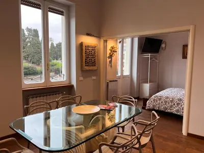 a room with a glass table and chairs and a bed at A Casa di Lu, al Colosseo - Guest House in Rome
