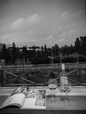 a book and two glasses of wine on a table at A Casa di Lu, al Colosseo - Guest House in Rome