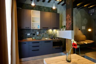 a kitchen with blue cabinets and a vase on a table at Mamaco Roma in Rome