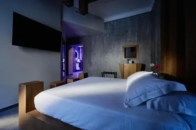 a bedroom with a large white bed and a television at Mamaco Roma in Rome