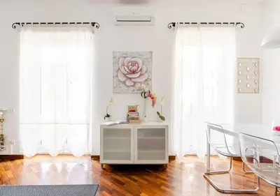 a dining room with white curtains and a table and chairs at Romely House St Peter Apartment in Rome