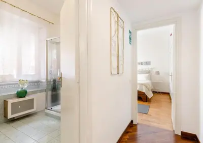 a white hallway with a room with a bedroom at Romely House St Peter Apartment in Rome