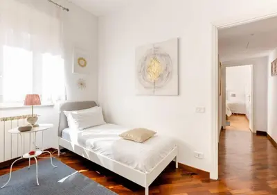 a white room with a bed and a table at Romely House St Peter Apartment in Rome