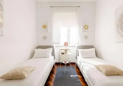 two beds in a room with white walls at Romely House St Peter Apartment in Rome