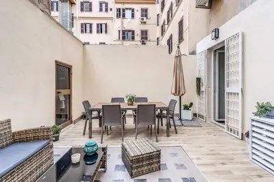 a patio with a table and chairs and an umbrella at NALA & KIRA - Two big apartments for groups in the center of Rome in Rome