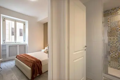 a bedroom with a bed and a window and a shower at Domus White in Rome
