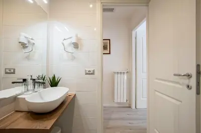 a white bathroom with a sink and a shower at Domus White in Rome