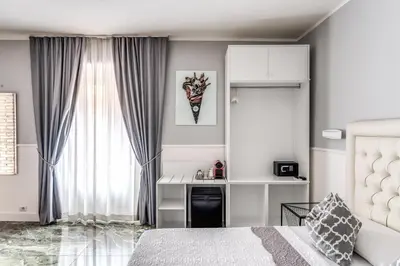 a bedroom with a bed and a desk and a window at Spanish Step Dream Suites in Rome