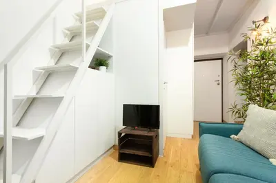 a living room with a staircase and a blue couch at Cozy Suite Saint John in Rome