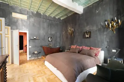 a bedroom with a bed and a black wall at Farnese Designer Loft by Romeloft in Rome