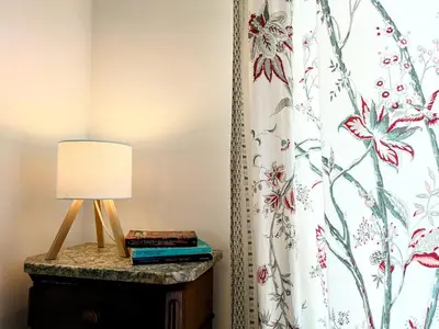 a lamp on a dresser next to a curtain at Il Nido di San Pietro - Cozy 2BR - Near Vatican in Rome
