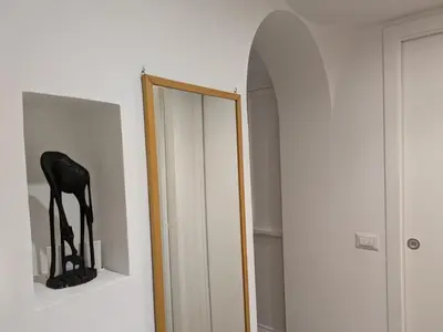 a mirror in a white room next to a closet at Il Nido di San Pietro - Cozy 2BR - Near Vatican in Rome