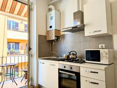 a kitchen with a stove and a microwave at Il Nido di San Pietro - Cozy 2BR - Near Vatican in Rome