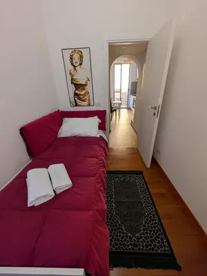 a bedroom with a red bed and a hallway at Il Nido di San Pietro - Cozy 2BR - Near Vatican in Rome
