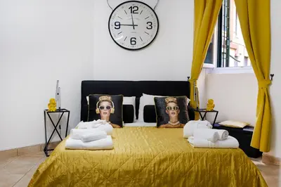 a bedroom with a bed with a clock on the wall at Dea Clodia studio flat in Rome