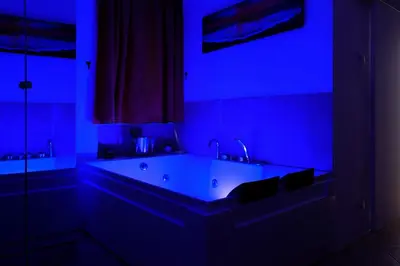 a bathroom with a large tub in a blue light at Dea Clodia studio flat in Rome