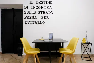 a table with two yellow chairs and a laptop on it at Dea Clodia studio flat in Rome