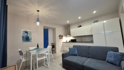 a living room and kitchen with a couch and a table at Light Blue Station Apartment in Rome