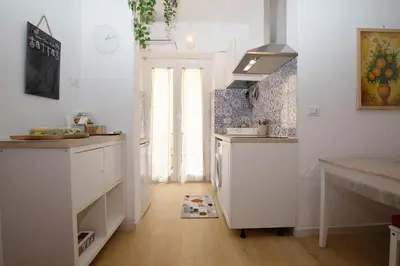 a kitchen with white cabinets and a refrigerator at Domus Appio Latino - Parco Appia Antica in Rome
