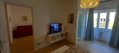 a living room with a flat screen tv on a stand at Domus Appio Latino - Parco Appia Antica in Rome