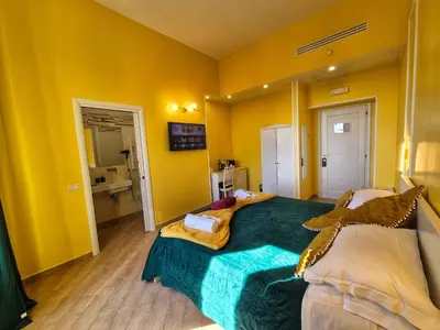 a bedroom with yellow walls and a large bed at Residenze Serventi Longhi in Rome