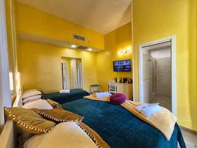 two beds in a room with yellow walls at Residenze Serventi Longhi in Rome