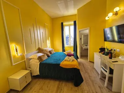 a bedroom with a bed in a yellow room at Residenze Serventi Longhi in Rome