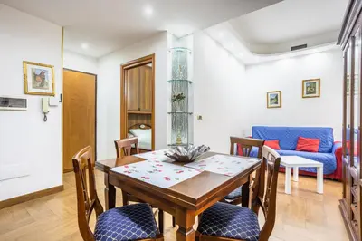 a dining room with a table and chairs and a couch at Portside Aparthotel in Rome